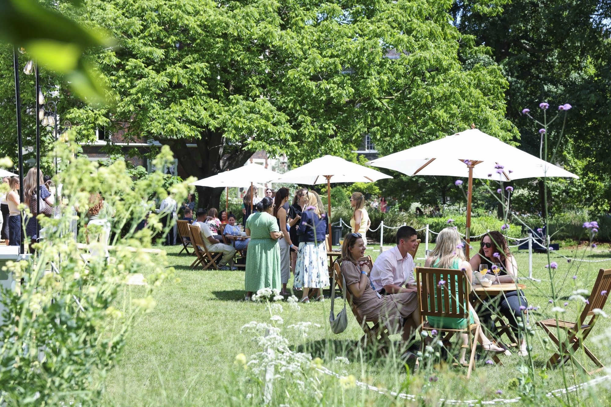 Guests under parasols on the lawn at Inner Temple Garden
